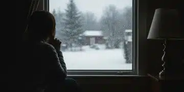 Pensive person looking at snowy winter landscape, symptoms of seasonal affective disorder
