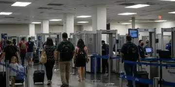 Travelers navigating a futuristic airport security checkpoint with new TSA technology.